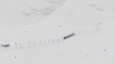 Zermatt, İsviçre - Gonergratbahn treni yoğun bir kar fırtınası sırasında Matterhorn 'u net bir şekilde gören ünlü turistik bölgedeki Gornergrat istasyonuna doğru koşuyor.. 