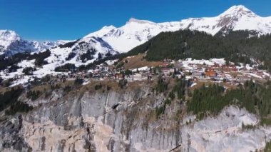 İsviçre 'deki Murren kayak merkezinin güzel panoramik hava manzarası. Uçurumun kenarındaki lüks oteller ve binalar.