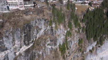 İsviçre 'deki Murren kayak merkezinin güzel panoramik hava manzarası. Uçurumun kenarındaki lüks oteller ve binalar.