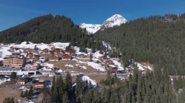 İsviçre 'deki Murren kayak merkezinin güzel panoramik hava manzarası. Uçurumun kenarındaki lüks oteller ve binalar.