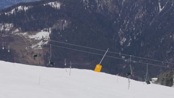 スイスのヴェーヴィエの空中撮影は 雪に覆われた斜面 スキー用の椅子付きのスキーリフト そして右側の駅を示しています — ストック動画