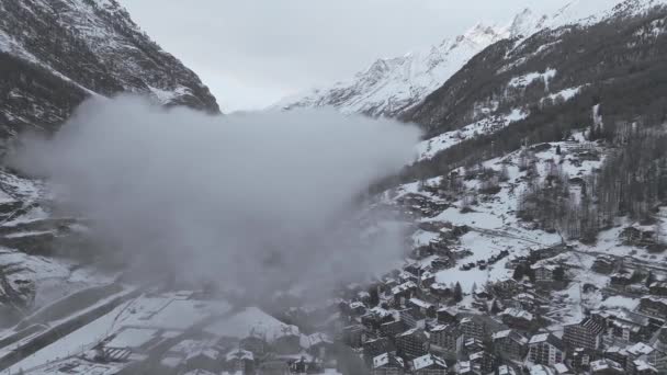 Zermatt是一家宁静的瑞士阿尔卑斯山滑雪胜地 空中拍摄的照片展示了雪地下的小木屋和现代设施 马特宏峰和雪峰在后面隐隐约约 形成了一个宁静庄严的冬季避风港 — 图库视频影像