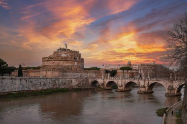 Roma, İtalya 'daki Tiber Nehri üzerindeki Castel SantAngelo ve Ponte SantAngelo köprüsünün manzarası. Tarihsel işaretler, nehir ve bulutlu gökyüzü mavi ipuçları ile.