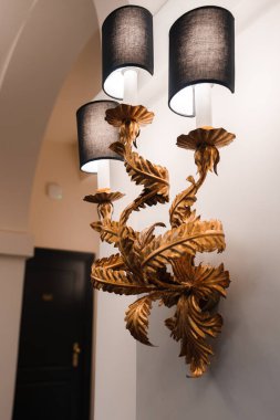 Roma 'da bir otelde yaprakları ve yaprakları olan bir dalı andıran altın kaplamalı lüks bir duvar döşenmiş. Sıcak ışıklandırma ortamı olan zarif bir dekor..