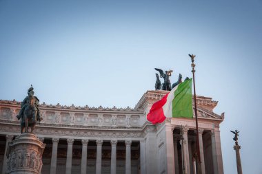 View Altare della Patria in Rome, Italy. Daytime shot with the national flag and equestrian statue. Monument features intricate details, symbolic statues, and historical significance. clipart