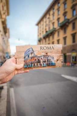 Kolezyum resimli ahşap kartpostal, ROMA ve COLOSSEO, bulanık şehir geçmişi. Roma, İtalya 'dan bir hatıra. Seyahat günlükleri için ideal.