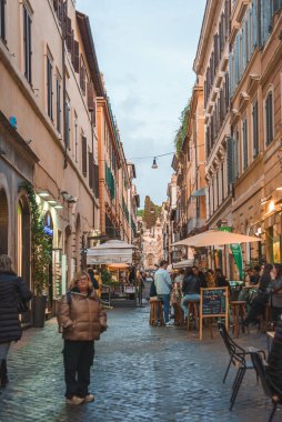 Büyüleyici Avrupa kaldırım taşı caddesi geleneksel binalarla dolu, hareketli. Bulutlu gökyüzü sıcak atmosfere ekleniyor. Konum bilinmiyor.
