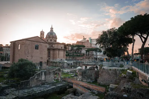 Roma Forumu, Roma, İtalya alacakaranlıkta antik harabeler ve arka planda harmanlanmış modern mimari ile. Tarihi önemi olan popüler turizm beldesi.