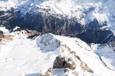 İsviçre 'deki Murren kayak merkezinin nefes kesici manzarası. Kar, tepeleri, kayak izlerini, köyü, İsviçre Alplerini, ışığı ve gölgeyi kapladı..