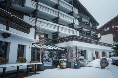 İsviçre, Zermatt 'taki lüks otel, karlı bir gün, alp elementli modern tasarım, ahşap balkonlar. Açık bar alanı karla kaplı. Kış tılsımı.