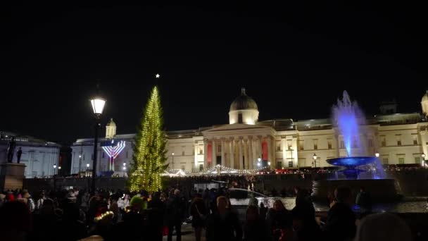 伦敦特拉法加广场的圣诞市场 圣诞树和玛瑙拉的夜景 数以百计的圣诞老人聚集在广场上 — 图库视频影像