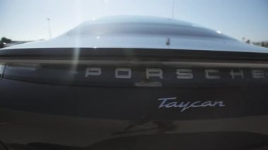 Porsche Taycan 'ın yakın görüntüsü. Güneşli bir günde lüks Porsche Taycan 'ın dışı.