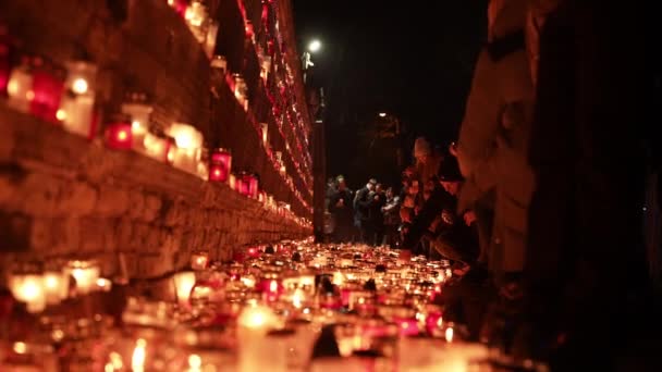 レッドキャンドルホルダーがシーンを照らすリガでの集会は リガ城近くのラトビアの独立記念日を敬意を表しています — ストック動画