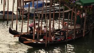 Venedik geleneksel gondolları Büyük Kanal 'daki tahta demirleme direkleriyle kenetlenmiş Santa Maria Della Salute, Venedik, İtalya.