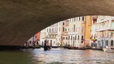 Gondol İtalya, Venedik 'teki Rialto Köprüsü yakınlarında. Venedik, İtalya 'da günbatımında Rialto Köprüsü ile ünlü Canal Grande' de geleneksel Gondolun güzel manzarası