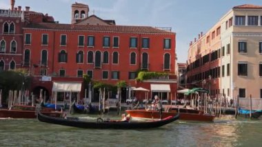 Venedik geleneksel gondolları Büyük Kanal 'daki tahta demirleme direkleriyle kenetlenmiş Santa Maria Della Salute, Venedik, İtalya.