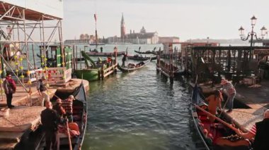 Venedik geleneksel gondolları Büyük Kanal 'daki tahta demirleme direkleriyle kenetlenmiş Santa Maria Della Salute, Venedik, İtalya.