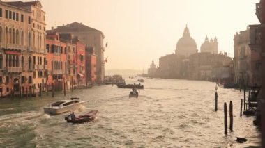Venedikli gondolcu Venedik İtalya 'nın yeşil kanal sularında gondola biniyor. Ünlü Canal Grande 'deki geleneksel Gondol manzarası gün batımında romantik altın bir akşam ışığı altında.