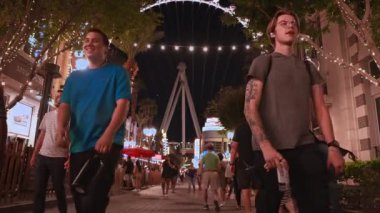 İnsanlar geceleri Las Vegas 'ta dünyanın en büyük gözlem tekeri olan dönme dolabın yakınındaki şehri keşfediyorlar..