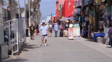Venice plaj bölgesindeki palmiye ağaçları ve binaların oradaki insanlar. Venedik plaj ruhu. Renkli binalar, tabelalar ve insanlar koşup paten kayıyor..
