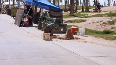 Venice plaj bölgesindeki palmiye ağaçları ve binaların oradaki insanlar. Venedik plaj ruhu. Renkli binalar, tabelalar ve insanlar koşup paten kayıyor..