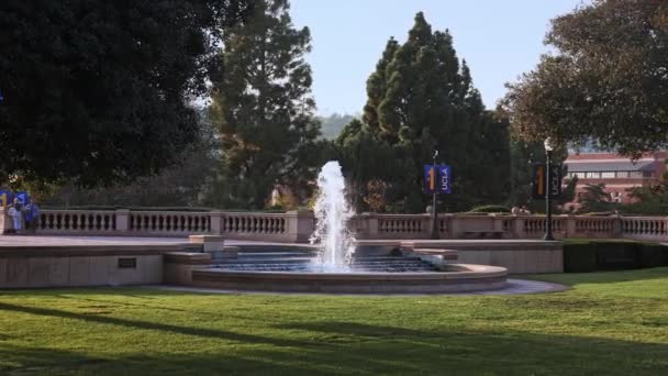 加州大学洛杉矶分校校区罗伊斯大厅的许多学生 罗伊斯大厅 Royce Hall 是加州大学洛杉矶分校韦斯特伍德分校 Uclas Westwood Campus 的四座原始建筑之一 学生们准备好晚上的比赛了 — 图库视频影像