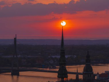 Letonya 'nın başkenti Riga' nın üzerinde sihirli hava günbatımı. Gün batımında şehir mimarisi ve Daugava Nehri ile Riga çatı manzaralı panorama.