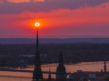 Letonya 'nın başkenti Riga' nın üzerinde sihirli hava günbatımı. Gün batımında şehir mimarisi ve Daugava Nehri ile Riga çatı manzaralı panorama.