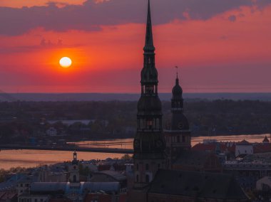 Letonya 'nın başkenti Riga' nın üzerinde sihirli hava günbatımı. Gün batımında şehir mimarisi ve Daugava Nehri ile Riga çatı manzaralı panorama.