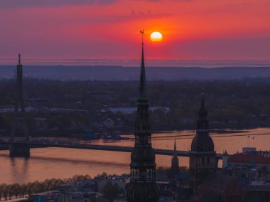 Letonya 'nın başkenti Riga' nın üzerinde sihirli hava günbatımı. Gün batımında şehir mimarisi ve Daugava Nehri ile Riga çatı manzaralı panorama.