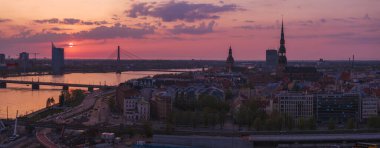 Letonya 'nın başkenti Riga' nın üzerinde sihirli hava günbatımı. Gün batımında şehir mimarisi ve Daugava Nehri ile Riga çatı manzaralı panorama.