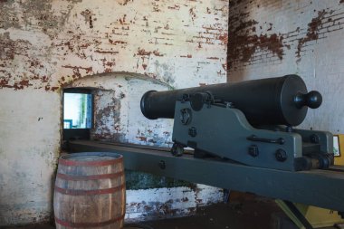 Alcatraz, San Francisco 'da eski bir odayı keşfet. Yeşil bir taşıma taşıma üzerinde antik bir top, soyulmuş boyayla yıpranmış duvarlar, ve bir varil tarihsel titreşimi güçlendiriyor..