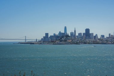 Panoramic view of San Francisco skyline from a vantage point, featuring San Francisco Bay, Bay Bridge, skyscrapers like Salesforce Tower and Transamerica Pyramid, serene atmosphere. clipart