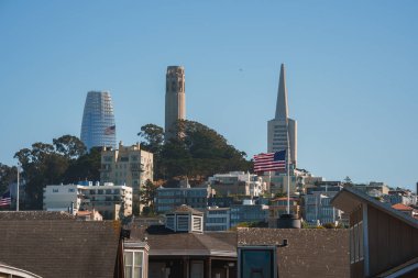 San Francisco manzaralı mimari tarzlar, konut binaları, Amerikan bayraklı tepe, Coit Tower, Transamerica Piramidi, açık mavi gökyüzü.
