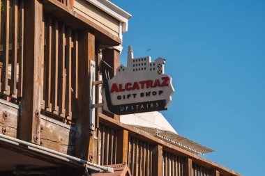 Alcatraz Hediyelik Eşya Dükkanı 'nın yön tabelası koyu kırmızı yazı tipi, beyaz ana hatları ve San Francisco 39..