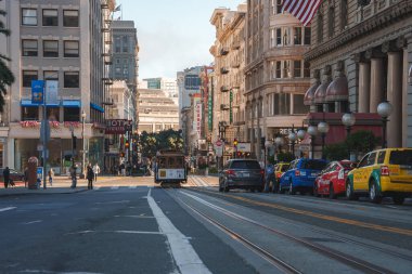 Explore the vibrant city scene of San Francisco, California. A classic cable car climbs an incline past a mix of modern and historic architecture, shops, and businesses. clipart