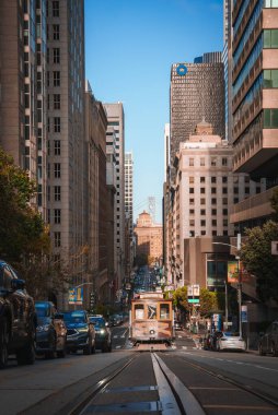 Canlı San Francisco sokak sahnesi ikonik teleferikli, yerli ve turistlerle dolu, tarihi ve modern mimari, güneşli bir gün, şehir atmosferi.