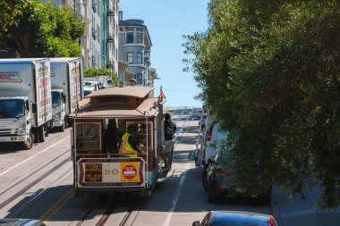 Classic San Francisco cable car ascending steep street with Victorian architecture and lush green trees. Blend of tourism and daily life. Sunny day vibe. clipart