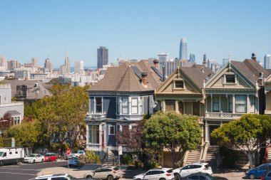 Viktorya dönemi evleri, Boyalı Kadınlar, San Francisco. Karmaşık detaylar, canlı renkler. Park etmiş arabaları, modern gökdelenleri, yüksek binaları, eşsiz gökdelenleri olan bir cadde. Kentsel gelişim.