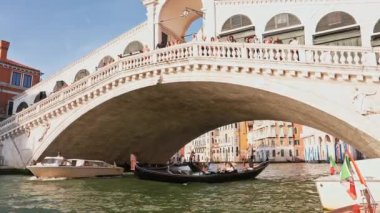 Gondol İtalya, Venedik 'teki Rialto Köprüsü yakınlarında. Venedik, İtalya 'da günbatımında Rialto Köprüsü ile ünlü Canal Grande' de geleneksel Gondolun güzel manzarası