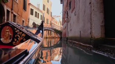 Gondol ile küçük bir Venezuela kanalından geçmek. Güzel gondol ve gondolcu eski Venedik kanalından geçiyor. Birinci kişi görünümü.