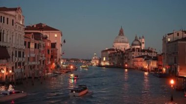 Ponte dellaccademia köprüsünden akşamları tekneler ve Santa Maria della Salute kilisesi ile Venedik Grand Canal manzarası. Venedik, İtalya