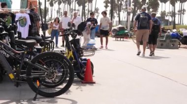 Venice plaj bölgesindeki palmiye ağaçları ve binaların oradaki insanlar. Venedik plaj ruhu. Renkli binalar, tabelalar ve insanlar koşup paten kayıyor..