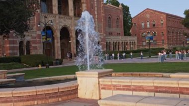 UCLA kampüsündeki Royce Hall 'da birçok öğrenci var. Royce Hall, UCLA Westwood kampüsündeki dört orijinal binadan biridir. Öğrenciler akşam maçına hazır..
