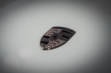Porsche amblemini açık arkaplanda siyah at şeklinde, üstünde PORSCHE, boynuzlu lüks araba markası Almanya 'dan..
