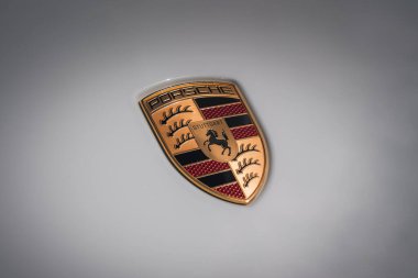 Açık arkaplanda altın, siyah ve kırmızı renkli Porsche amblemi. Wurttemberg ve Stuttgart arması. Parlak bitiş derinlik ekler.