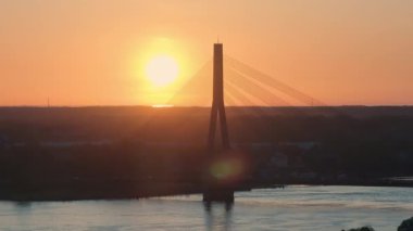Riga, Letonya 'da gün batımında asma köprü. Daugava nehrinin üzerindeki güzel günbatımının hava manzarası..