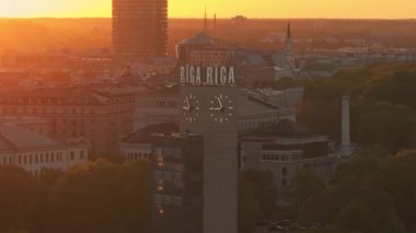 Riga 'nın Letonya' daki eski kasabasında hava panoramik günbatımı. Riga 'da güzel bir bahar günbatımı. Riga saat kulesi tren istasyonunun yakınındaki manzarayı kapat. Altın saat yangın günbatımı.