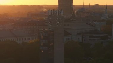 Riga 'nın Letonya' daki eski kasabasında hava panoramik günbatımı. Riga 'da güzel bir bahar günbatımı. Riga saat kulesi tren istasyonunun yakınındaki manzarayı kapat. Altın saat yangın günbatımı.