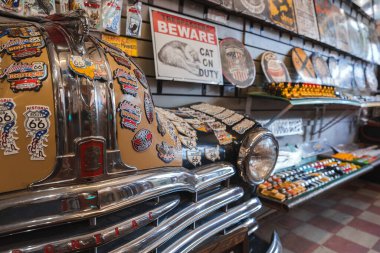 Explore a vintage souvenir shop near the Grand Canyon with nostalgic Pontiac car adorned in stickers celebrating Route 66. Classic Americana feel awaits in Williams Town. clipart